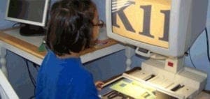 Person using an electronic magnifier to read large text on a screen.