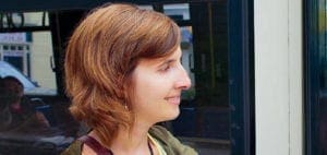 Lesley University student smiles while looking out a window.