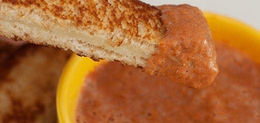 Slice of toast dipped in tomato soup.