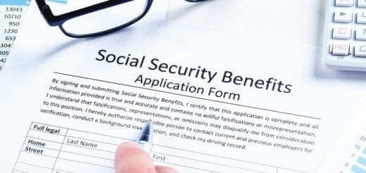 Social Security Benefits Application Form with a hand holding a pen.