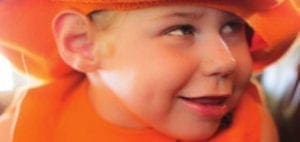Hannah Metsch smiling in an orange hat and vest.