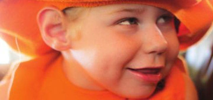 Hannah Metsch smiling in an orange hat and vest.