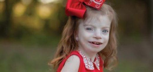 Emma Elizabeth Largent smiling with a red bow in her hair.