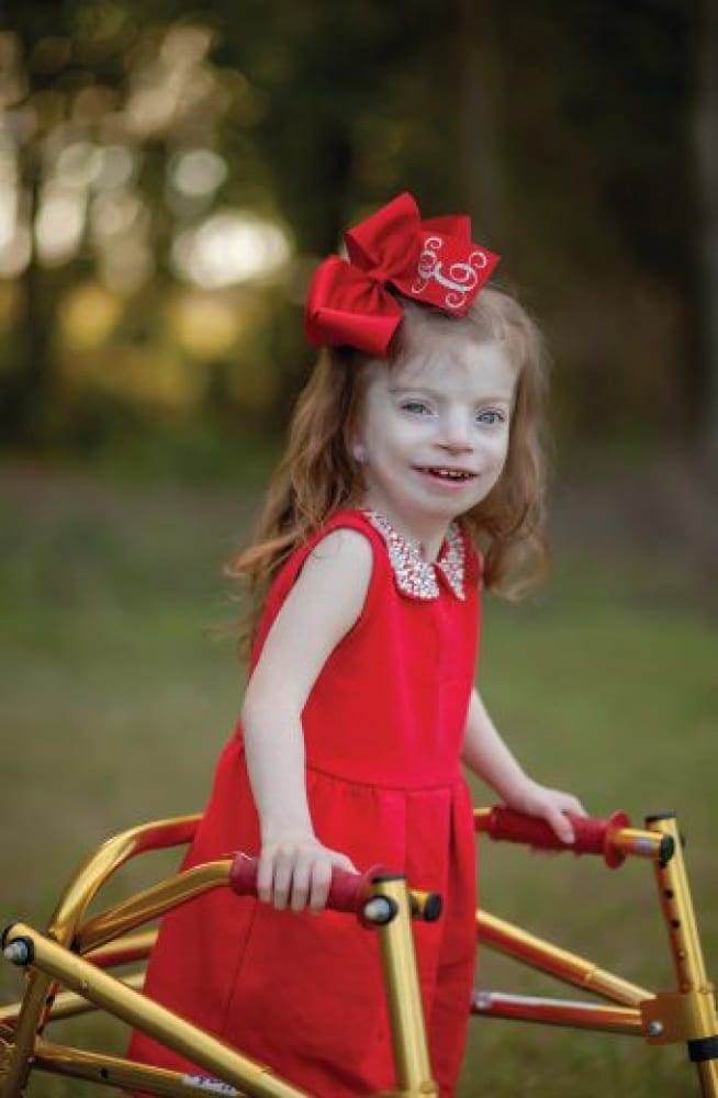Emma Elizabeth Largent in a red dress with a walker.