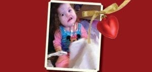 Grace Hope in a Minnie Mouse shirt and pink pants with a heart ornament.