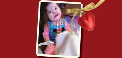 Grace Hope in a Minnie Mouse shirt and pink pants with a heart ornament.