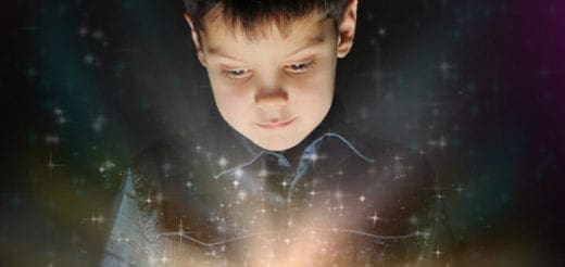Boy looking down at glowing light with sparkles
