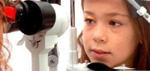 Child undergoing an eye examination with specialized equipment.