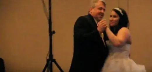 A father and his daughter dance together.