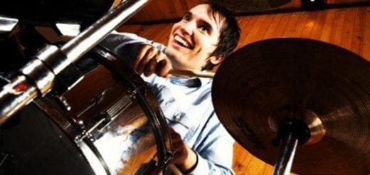Drummer laughing while playing drums