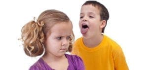 Boy sticking tongue out at girl with disgusted expression