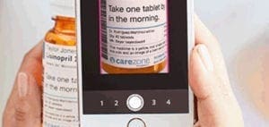Smartphone displaying medication instructions next to pill bottle.