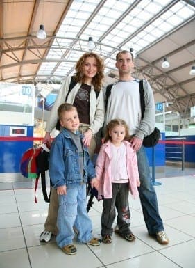 Family poses for a photo at an indoor travel terminal.