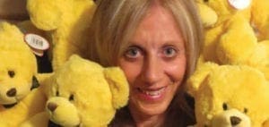 Carol Cooper surrounded by yellow teddy bears
