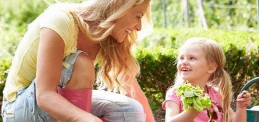 A mother and daughter gardening together outdoors.