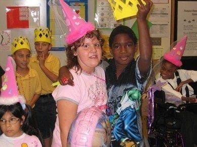 Children in party hats at a birthday celebration.