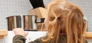 Child reaching for a pot on a stove