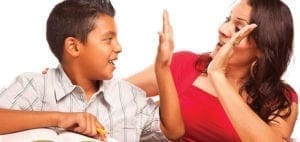 A boy and a woman give each other high fives.