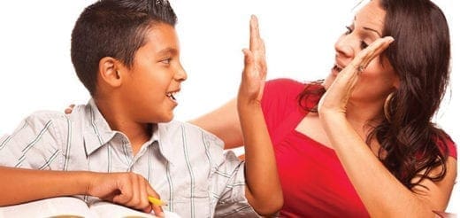 A boy and a woman give each other high fives.