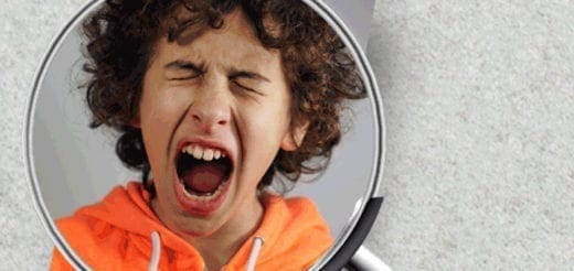 Child in orange hoodie screaming through a magnifying glass.