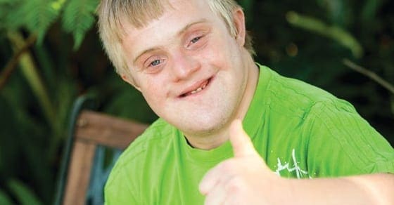 Young person with Down syndrome giving a thumbs up