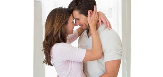 Couple embracing with their foreheads touching in an intimate moment at home.