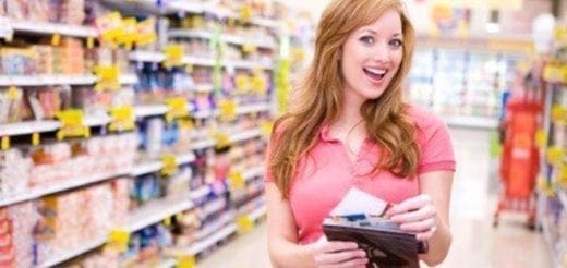 Person holding a wallet and receipt in a grocery store aisle.