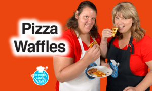 Two women hold up pizza waffles against an orange background.