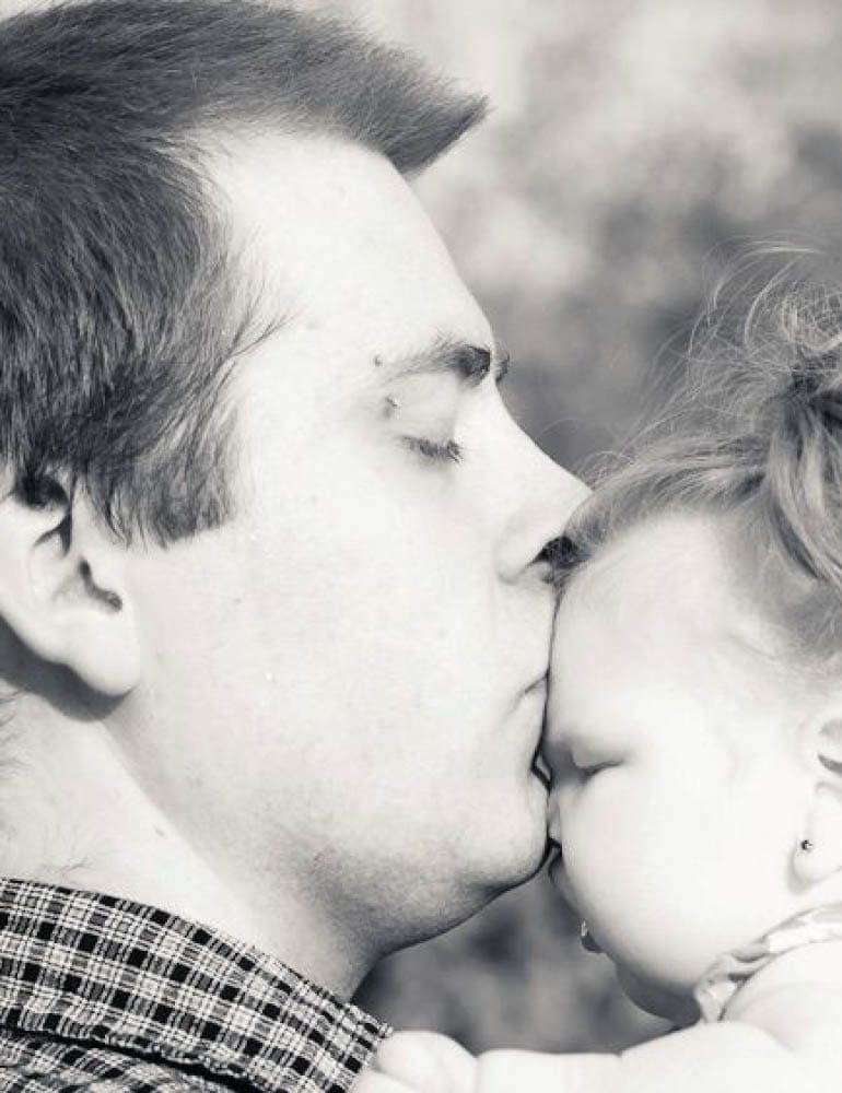 Isabel receiving a kiss from her father.