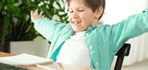 Young boy with arms outstretched, smiling with eyes closed.