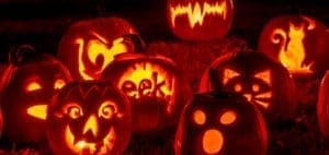 Several carved and illuminated Halloween pumpkins with various spooky faces and shapes.