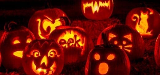 Several carved and illuminated Halloween pumpkins with various spooky faces and shapes.