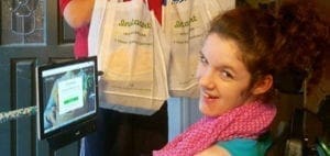 Woman in a wheelchair smiles near a tablet screen displaying the Instacart app.