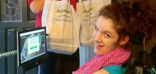 Woman in a wheelchair smiles near a tablet screen displaying the Instacart app.