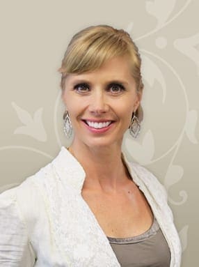 Paula Kettula smiling with decorative background.