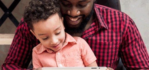 Father and son looking at a tablet together.