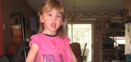 Young girl in a pink shirt holds a pink ball.