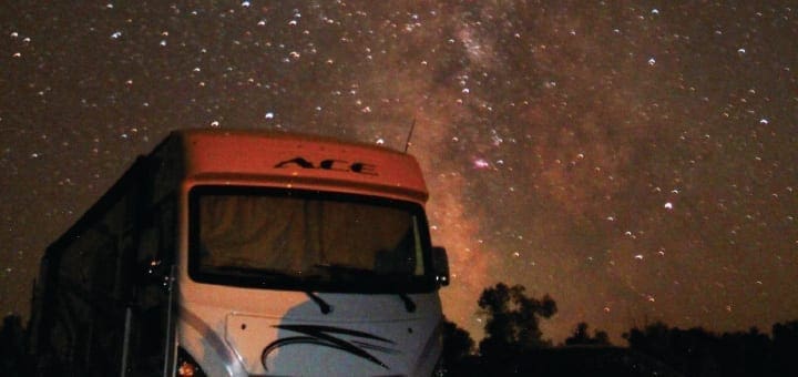 Camper van under a starry night sky