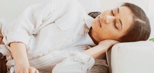 Woman resting her head on a couch cushion.