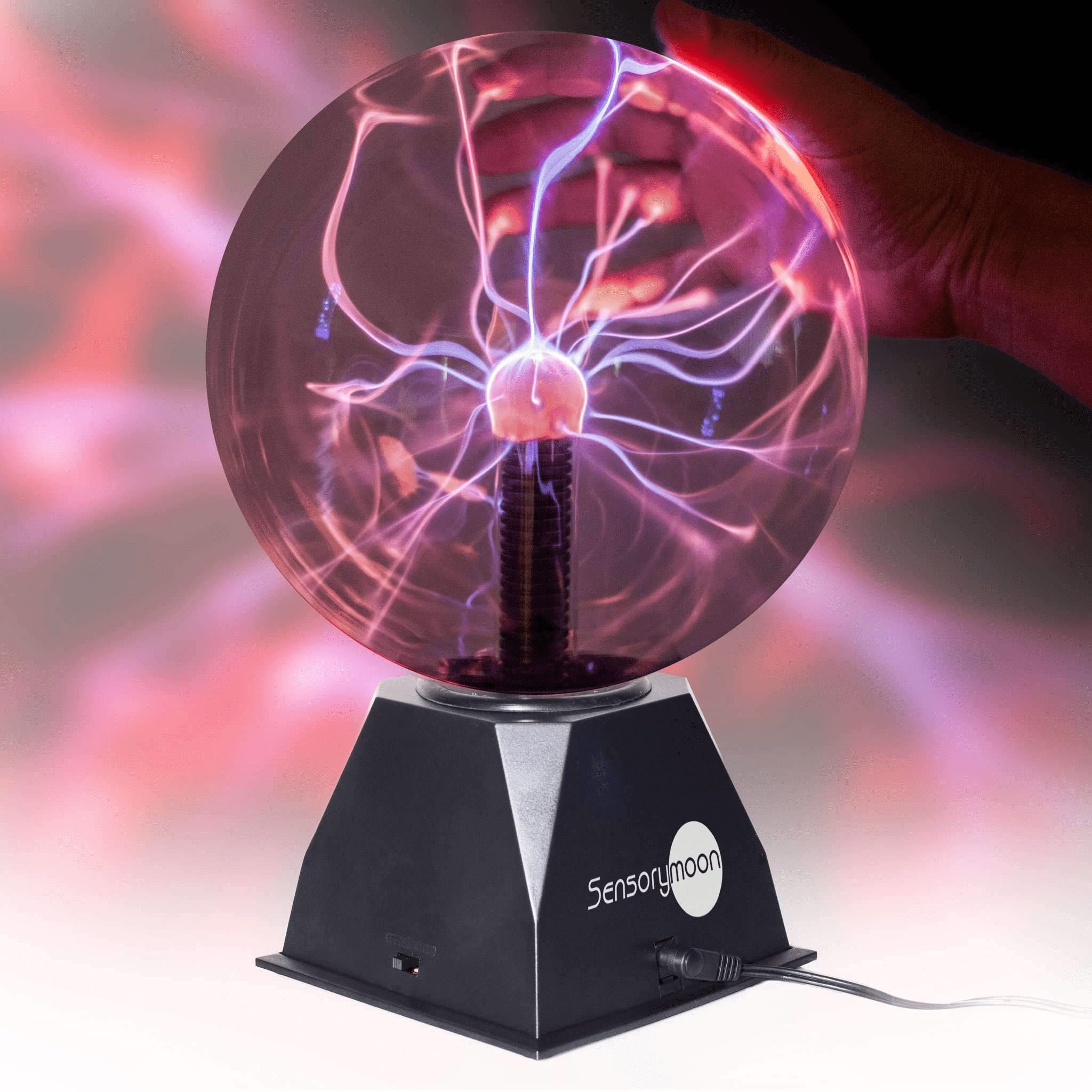 Plasma ball with purple and pink light tendrils emanating from the center, with a hand touching the glass.