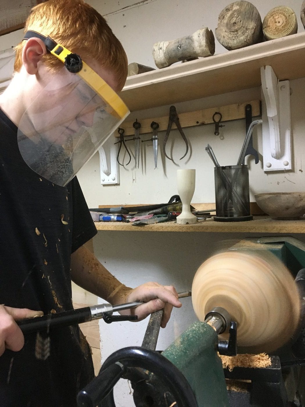 Austin Bruder using a wood lathe to craft a bowl.