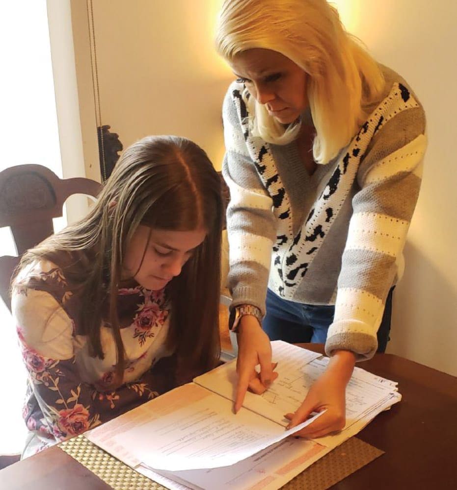 The Longs: Mom, Kelly, helping Kamryn do her 12 grade school work since classes are now at home.