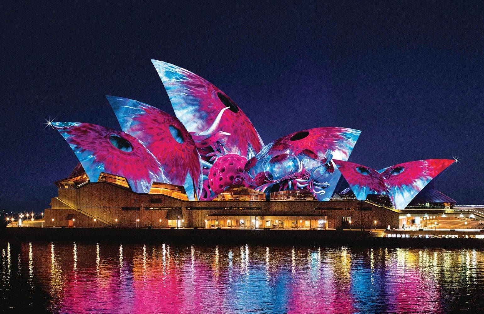 Sydney Opera House illuminated with colorful lights at night
