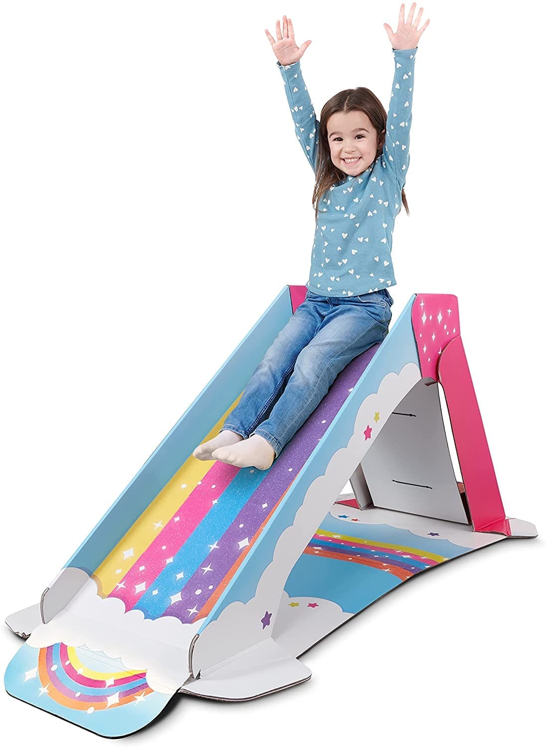 A young girl with her arms raised sits at the top of a rainbow slide.