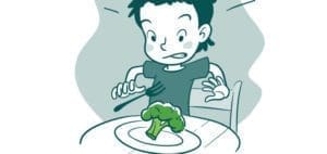 A child recoils from a piece of broccoli on a plate.