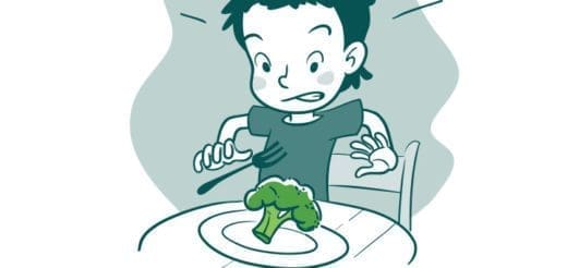 A child recoils from a piece of broccoli on a plate.