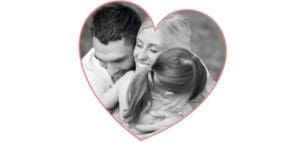 A family embraces within a heart shape.