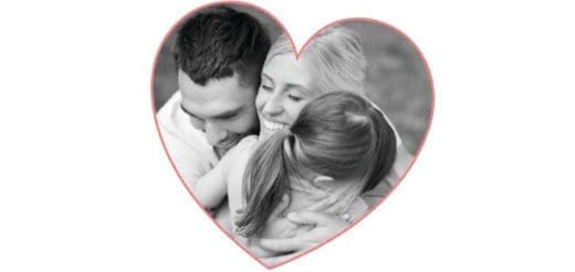 A family embraces within a heart shape.