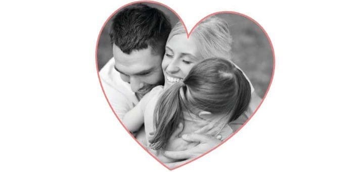 A family embraces within a heart shape.