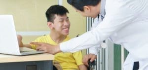 Doctor and patient looking at a laptop in a healthcare setting.